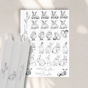 Może przedstawiać: Arkusz czarno-białych naklejek wielkanocnych z królikami, kurczakami i jajkami. Naklejki mają napis "Happy Easter" powtórzony dwa razy.
