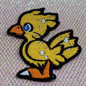 May include: Yellow embroidered iron-on patch of a cartoon chick with white accents and blue eyes.
