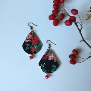 Orecchini di carta pendenti neri con rose rosse.