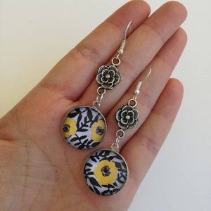 Orecchini pendenti floreali cammeo color argento con  immagini con fiore giallo e in bianco e nero e ciondolo a fiore color argento