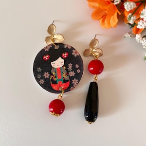 Orecchini di carta asimmetrici con ciondolo a forma di cerchio,  immagine di bambolina kokeshi e perle rosse e nere
