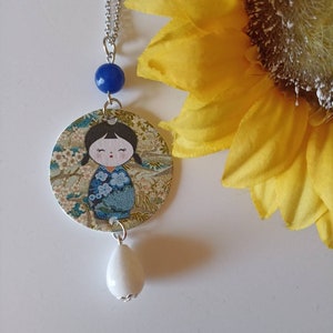 Collana lunga con ciondolo di carta con immagine di bolina kokeshi giapponese con pietre blu e bianche