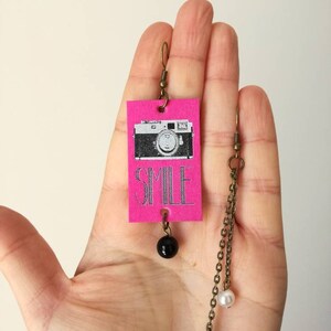Pendentif rectangulaire asymétrique et carte boucles d’oreilles vintage image avec caméra et écrits de sourire !