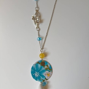 Collana lunga con ciondolo a cerchio di carta, bellissima immagine floreale e perle gialle e azzurre.