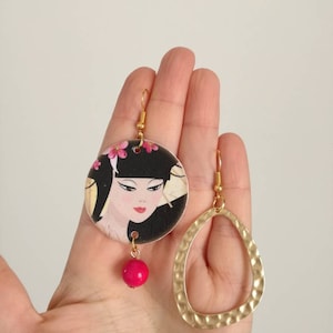 Orecchini di carta pendenti asimmetrici con ciondolo a forma di cerchio e immagine di gheisha con perla fucsia.