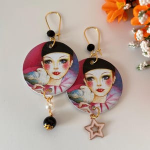 Mira Fujita orecchini di carta pendenti con volto di donna, perlina nera e piccolo ciondolo a forma di stella rosa