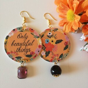 Orecchini di carta pendenti con ciondolo a cerchio fantasia floreale e frase motivazionale "only beautiful things".