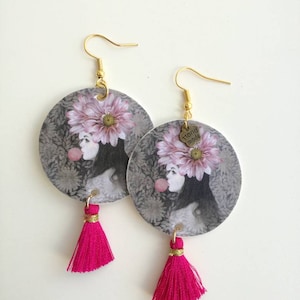 Orecchini di carta con ciondolo a forma di cerchio e immagine di donna con fiore e nappine di cotone fucsia