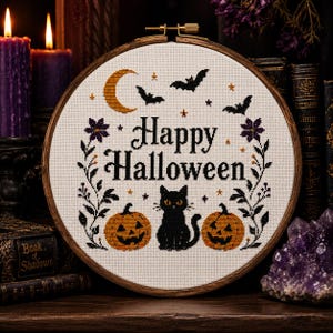 Può includere: Un telaio da ricamo circolare in legno contenente un disegno a punto croce su tessuto bianco. Il disegno presenta il testo Happy Halloween in nero, una mezzaluna gialla, pipistrelli neri, due zucche arancioni e un gatto nero.