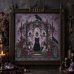 May include: A cross-stitch embroidery in a dark ornate frame featuring a black cat sitting under a gothic archway adorned with pink roses and purple wisteria. Two black ravens, hanging lanterns, and glowing candles surround the cat, set against a muted purple background with a crescent moon symbol.