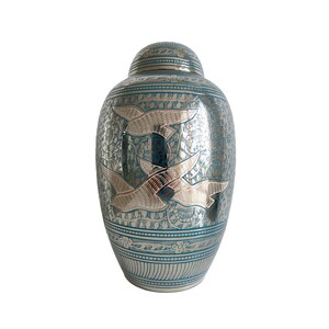 May include: A silver and blue cremation urn with a design of three birds in flight. The urn has a decorative pattern on the body.