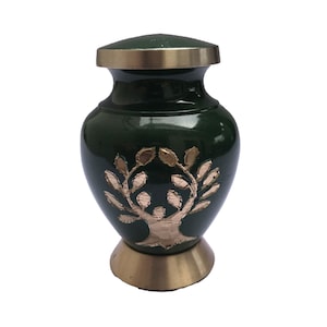 Pode incluir: Uma pequena urna verde com um design de árvore dourada. A urna tem uma tampa e uma base de latão.