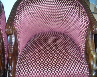 May include: Two brown wooden chairs with a burgundy and gold diamond patterned upholstery.