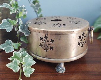 Round brass incense box with lid ring handles claw feet and decorative cutout design