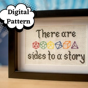 Pode incluir: Um design de ponto cruz emoldurado com o texto "There are sides to a story" e uma fileira de dados coloridos.