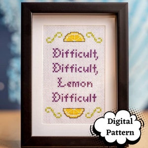 May include: A framed cross-stitch pattern with the text "Difficult, Difficult, Lemon, Difficult" in purple lettering and two yellow lemons with green stems. The text is surrounded by green swirls. The frame is black and the background is white. The text "Digital Pattern" is in a speech bubble in the lower right corner.