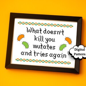 May include: A framed cross-stitch design with the text "What doesn't kill you mutates and tries again." The design features green and orange pixelated bacteria and a speech bubble with the text "Digital Pattern".