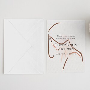 May include: A card with a brown line drawing of a person's head and shoulders. The text on the card reads "There is no right or wrong way to grieve. There's only your way. And I'm here for you."