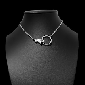 May include: A silver necklace with a hand holding a circle pendant.