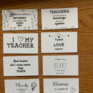 May include: A set of ten black and white cards with inspirational quotes for teachers. The quotes include "You are making a difference every day", "Teachers plant the seeds of knowledge that last a lifetime", "I love my teacher", "Teach love inspire", "Real heroes don't wear capes, they teach", "It takes a big heart to help shape little minds", "Thanks for helping me to make my future bright", "Teachers live forever in the hearts they touch", "Teaching is a work of heart", and "You are making a difference every day".