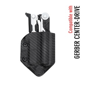 May include: A black carbon fiber holster for a Gerber Center-Drive multi-tool. The holster has two black screws on the side and is compatible with the Gerber Center-Drive multi-tool.