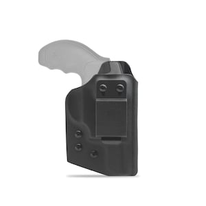 Puede incluir: Funda de cuero negra con un clip y un mango de pistola gris en el interior. La funda tiene varios tornillos y un pequeño logotipo cuadrado.