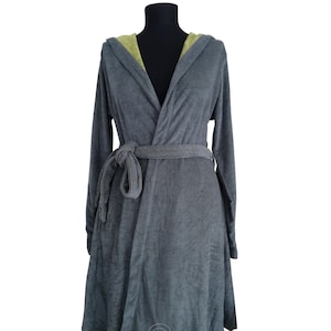 Könnte beinhalten: Ein grauer Bademantel mit Kapuze und grüner Kapuzenfutter. Der Bademantel hat einen Bindegürtel und ist aus weichem, plüschigem Material gefertigt. Der Text "BATHROBE FROM DENIZLI TURKEY" ist auf der Unterseite des Bademantels aufgedruckt.