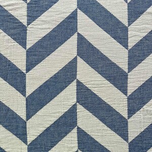 May include: A blue and white chevron patterned textile. The design features alternating blue and white diagonal stripes, creating a zig-zag effect. The fabric has a slightly textured appearance. The brand name "masumi" is visible in the bottom right corner.
