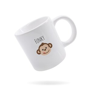 May include: White ceramic mug with a brown monkey face and the word "FUNKY" printed in black.