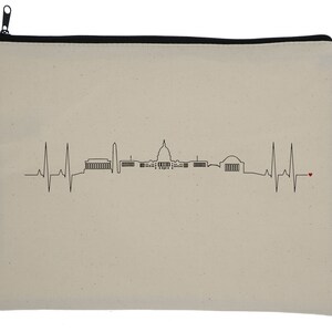 May include: A beige canvas zippered pouch featuring a black line drawing of the Washington, D.C. skyline. The design incorporates a heartbeat line with a small red heart. The zipper is black.