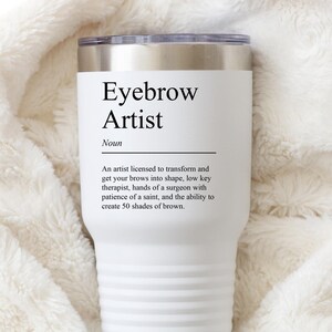 以下が含まれることがあります： 白のステンレス製のタンブラーで、前面に黒と白の「アイブロウアーティスト」の定義が書かれています。定義は次のとおりです。「眉を形作り変えるためのライセンスを持つアーティスト、控えめなセラピスト、外科医の手、聖人の忍耐力、そして50色のブラウンを生み出す能力。」