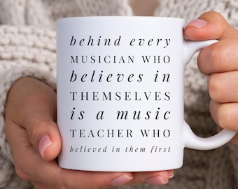 Może przedstawiać: Biały kubek ceramiczny z czarnym tekstem, który brzmi: "behind every MUSICIAN WHO believes in THEMSELVES is a music TEACHER WHO believed in them first".