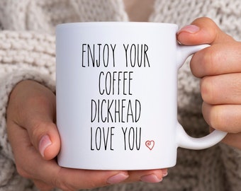 May include: White ceramic coffee mug with black text that reads "Enjoy your coffee dickhead love you" with a small red heart.