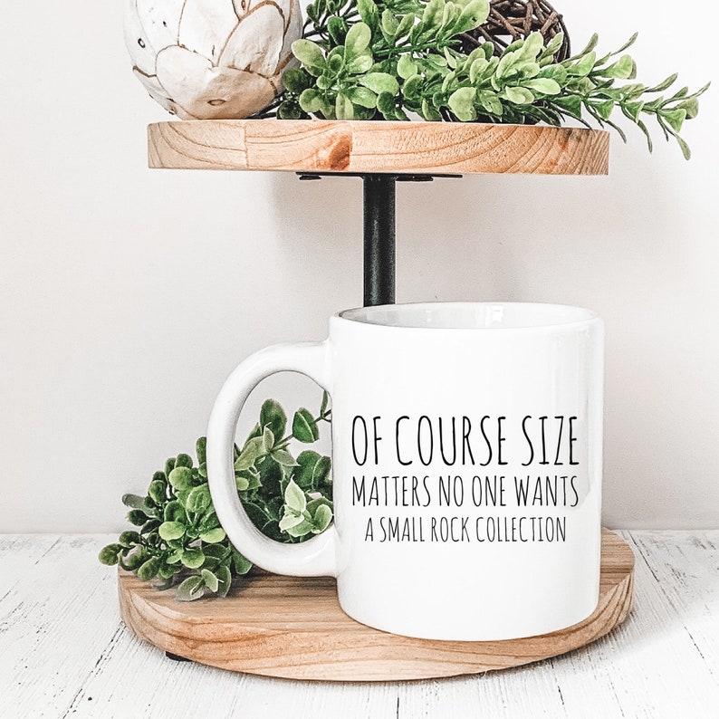 May include: White ceramic mug with black text that reads "Of course size matters no one wants a small rock collection".