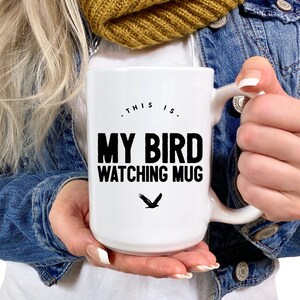 May include: White ceramic mug with a black design that says "This is my bird watching mug" with a black silhouette of a bird underneath the text.