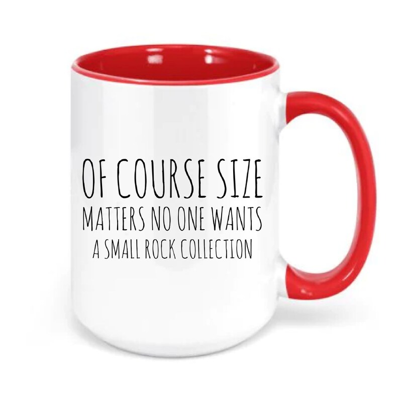 May include: White ceramic mug with a red rim and handle. The mug has black text that reads "Of course size matters no one wants a small rock collection."