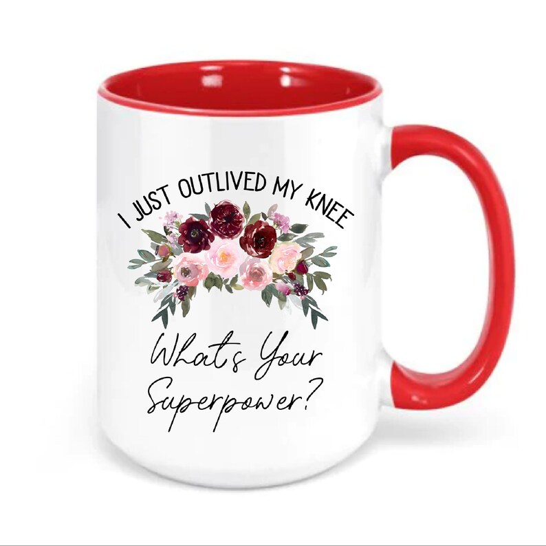 Pu&ograve; includere: Tazza in ceramica bianca con bordo e manico rossi. La tazza presenta un motivo floreale con fiori bordeaux e rosa e il testo "I just outlived my knee. What's your superpower?"