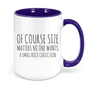 May include: White ceramic coffee mug with a purple rim and handle. The mug has the text "Of course size matters no one wants a small rock collection" printed on it.