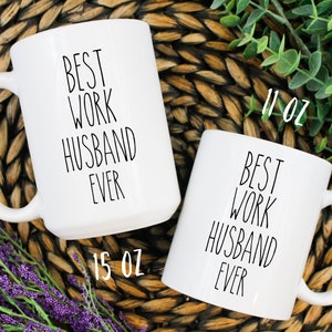 May include: Two white ceramic mugs with black text that reads "Best Work Husband Ever". The larger mug is 15 oz and the smaller mug is 11 oz.