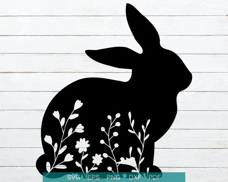 May include: Black silhouette of a rabbit with floral details. The rabbit is facing right and has long ears. The floral details are white and are scattered around the rabbit's body.