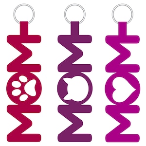 May include: Three keychains with the word "MOM" in a zig-zag pattern. The keychains are in red, purple, and pink. The middle keychain has a white cat silhouette, the left keychain has a white paw print, and the right keychain has a white heart.