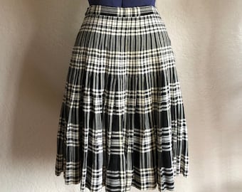 May include: A black and white plaid skirt with pleats. The skirt is knee-length and has a fitted waist.