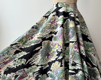 May include: A full skirt in black and white with a vintage-inspired print of a countryside scene. The print features houses, trees, and horses in shades of green, red, and yellow.