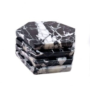 May include: Set of six black and white marble hexagonal coasters. The coasters are stacked on top of each other.