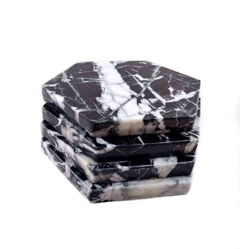 May include: Set of six black and white marble hexagonal coasters. The coasters are stacked on top of each other.