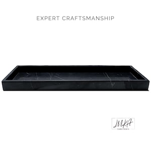 This black marble tray showcases expert craftsmanship with its polished finish and smooth edges. The natural white veining adds a luxurious touch, making it perfect for serving, organizing, or decorating.
