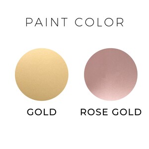 May include: Two paint color swatches, one gold and one rose gold.  The paint color swatches are round and have a metallic finish.