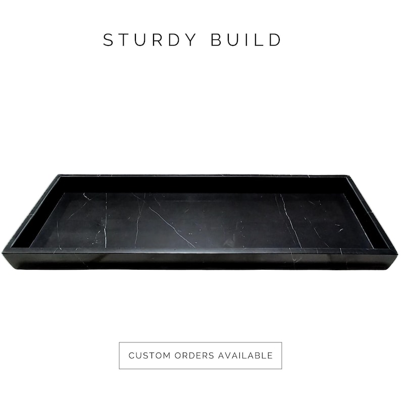 Front view of a rectangular black marble serving tray with natural white veining and polished edges. Its sturdy build ensures durability, making it ideal for serving or organizing. Available in custom sizes and stone options to match any decor.