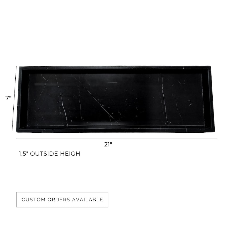 Top view of a 7" x 21" black marble serving tray with 1.5" outside height, showcasing a rectangular design with natural white veining. This durable and polished tray offers custom sizes and stone options to suit any space.