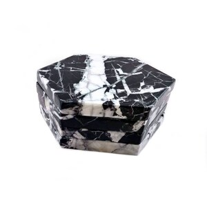 May include: Set of four black and white marble hexagonal coasters. The coasters are stacked on top of each other.